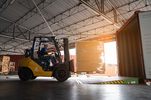 Warehouse worker loading pallet product