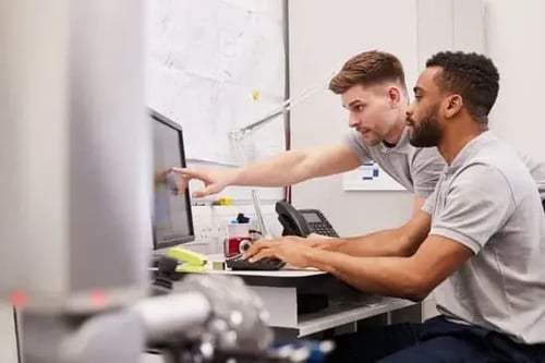 Engineers around a computer